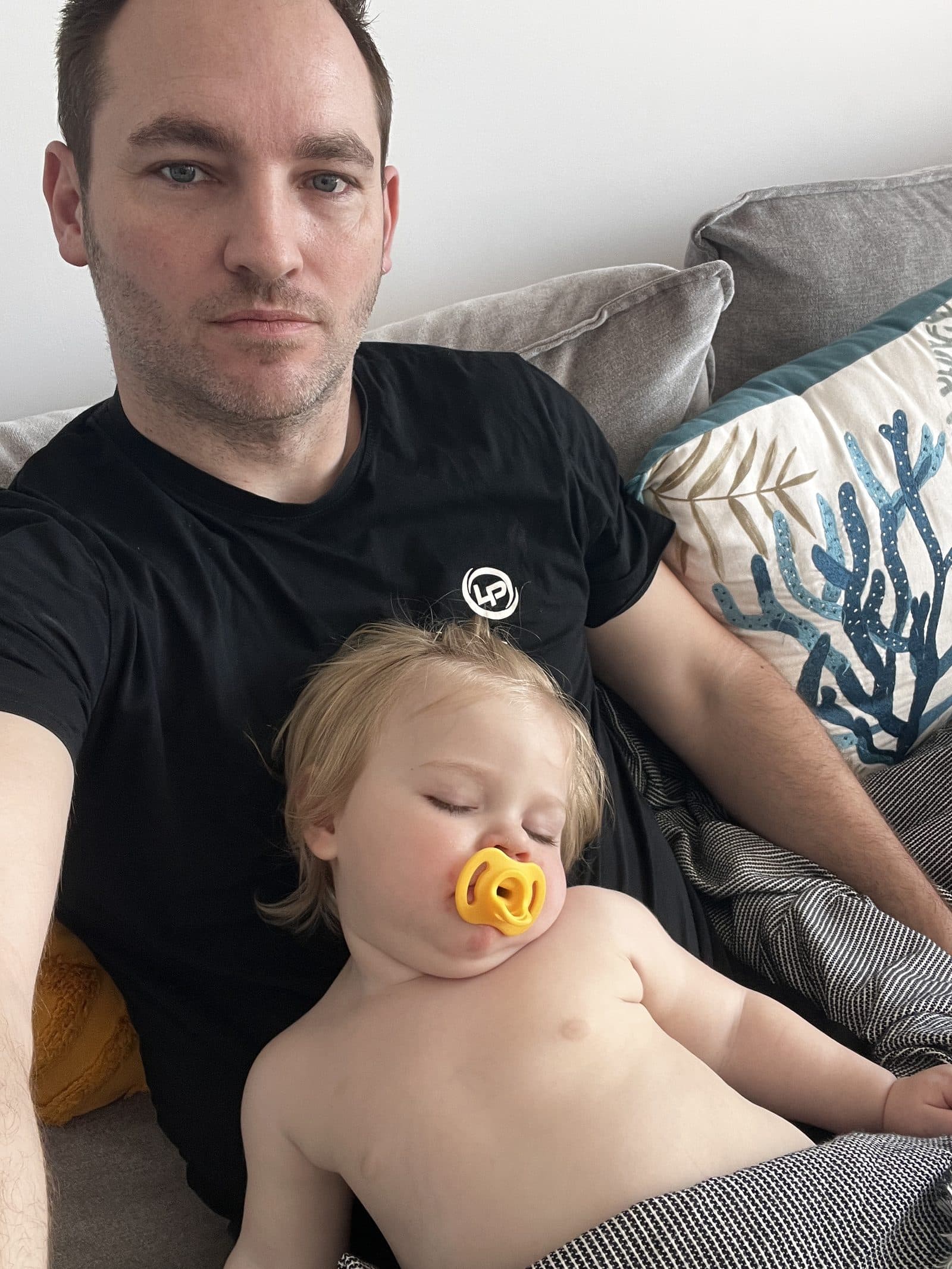 Dad and Tallulah napping together on the apartment sofa in Benidorm