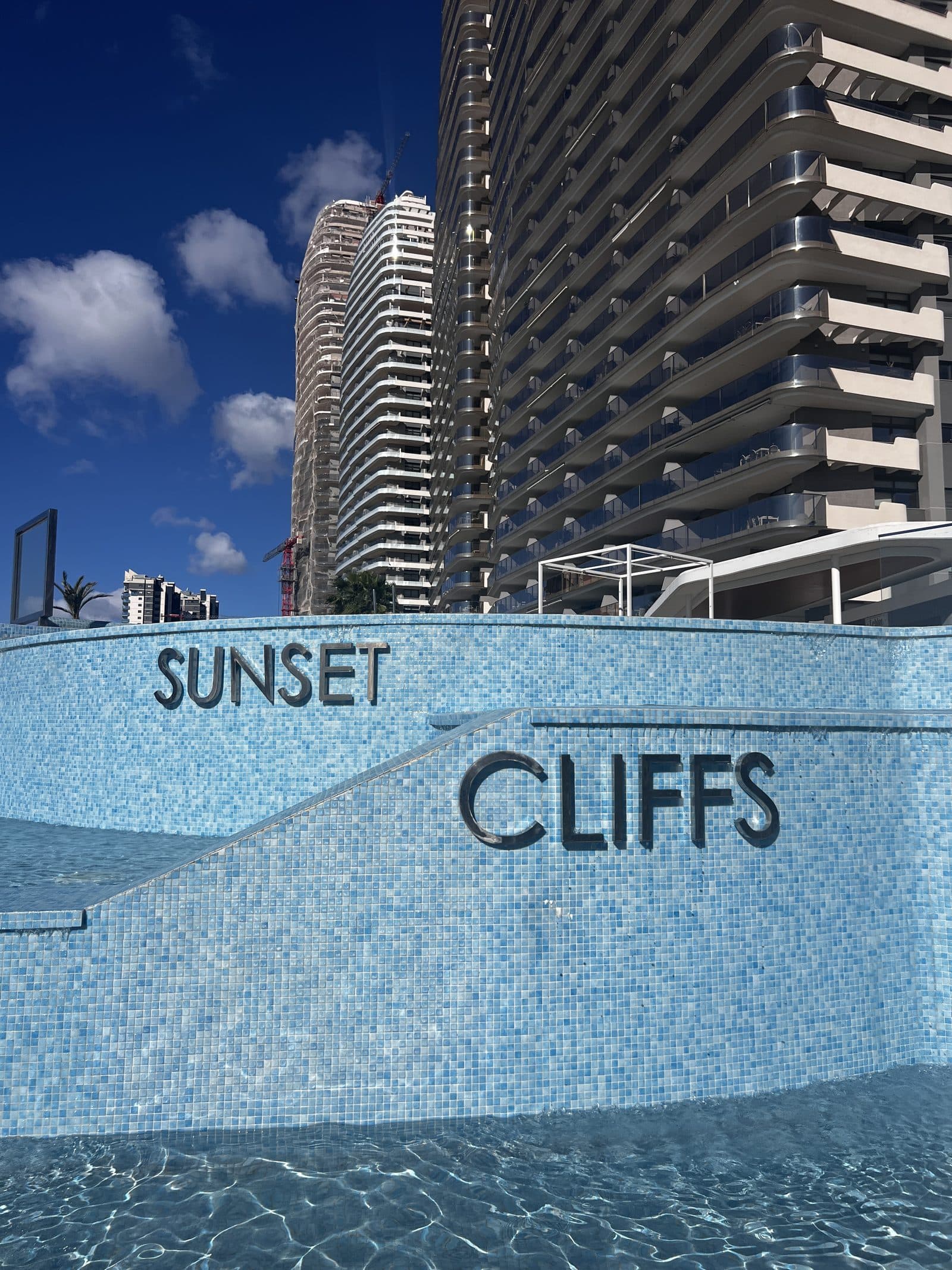 Sunset Cliffs apartment building in Benidorm with blue mosaic pool edge and Sunset Cliffs sign