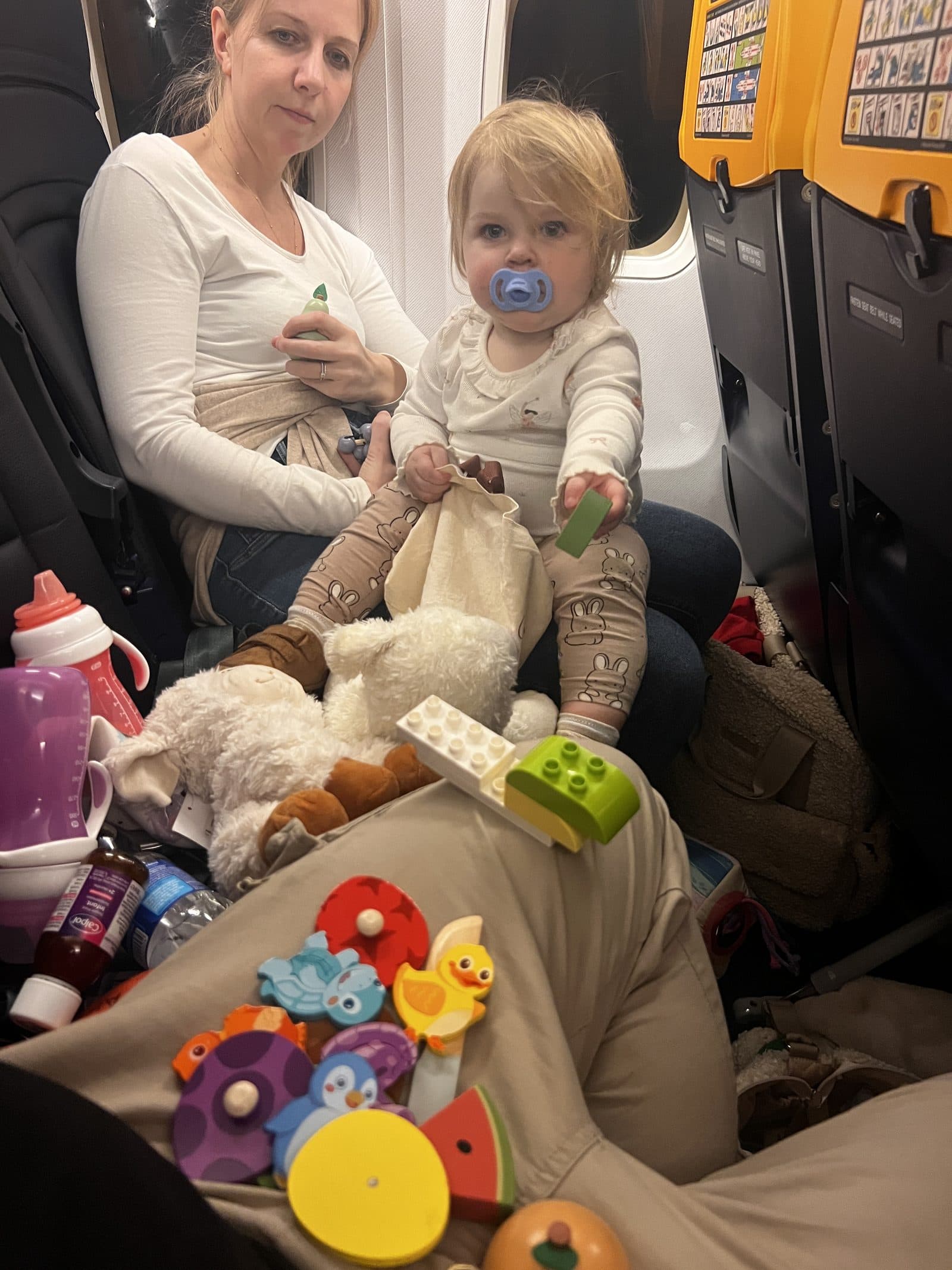 The reality of flying Ryanair with a baby - toys, bottles, dummies and Duplo spread across the seats