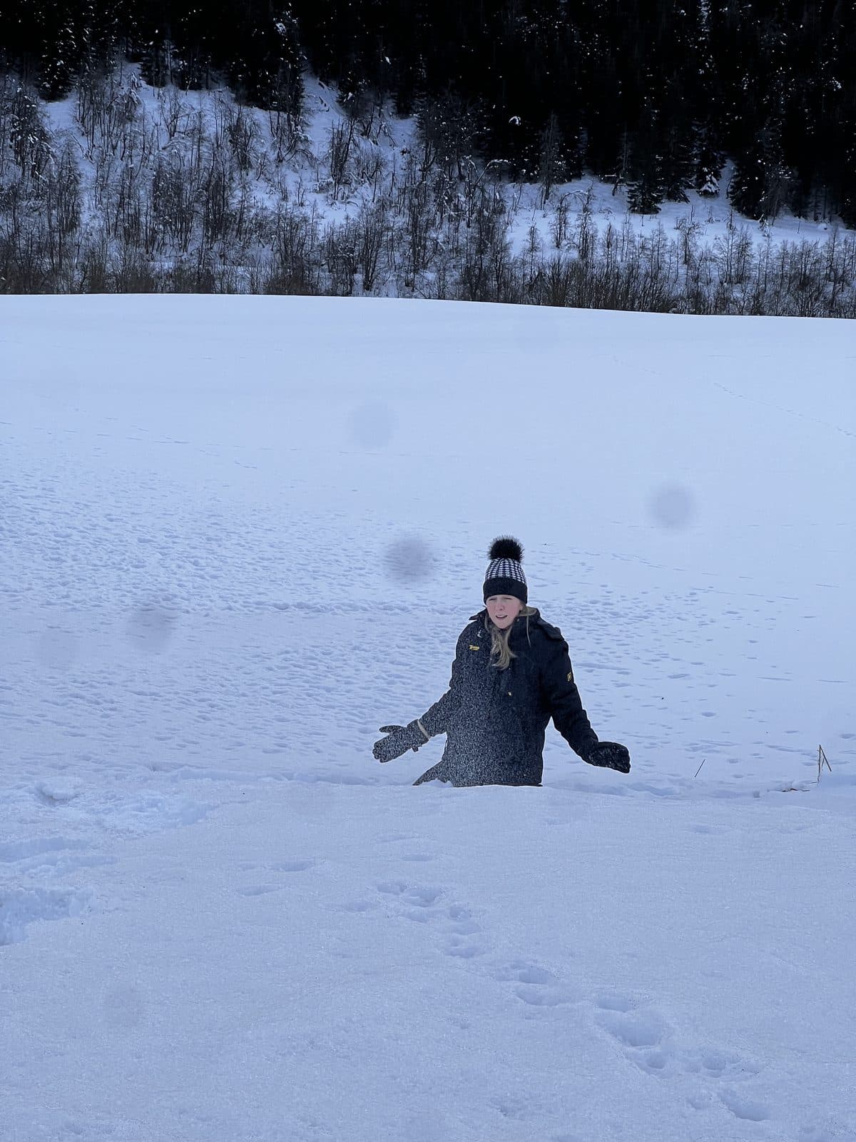 Woman standing in deep snow at Myrkdalen ski resort Norway with snow-covered trees