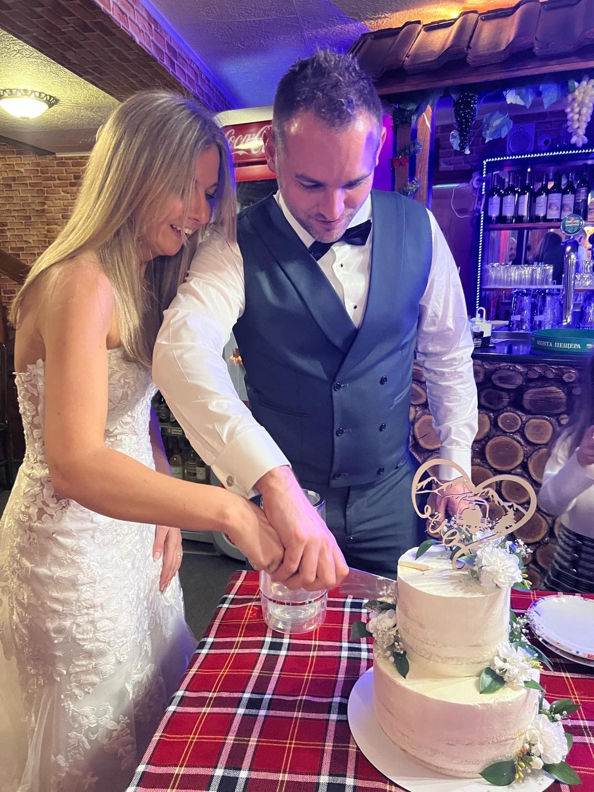 Liam and Leila cutting their wedding cake in Borovets, Bulgaria