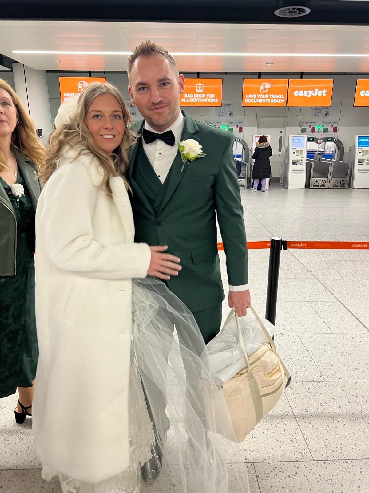 Liam and Leila in wedding attire at the easyJet check-in desk at Gatwick airport