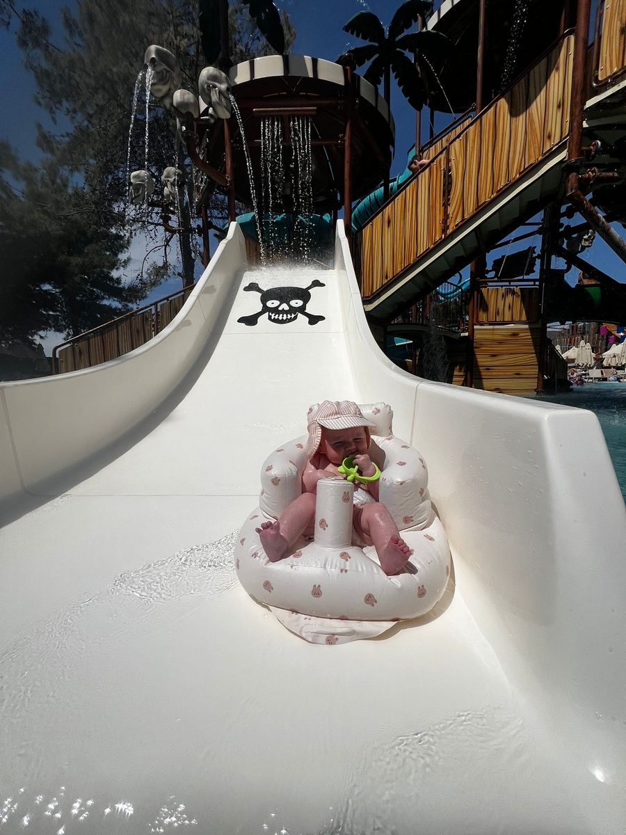 Baby in inflatable float at the bottom of the pirate water slide at all-inclusive resort in Turkey